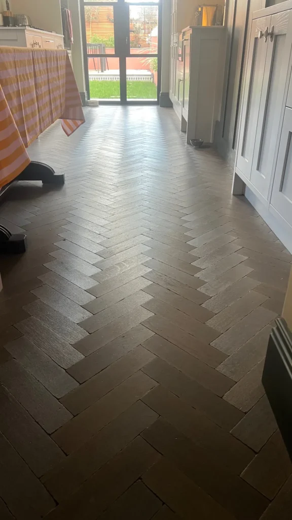 Pale herringbone wood floor fitted in open-plan dining space